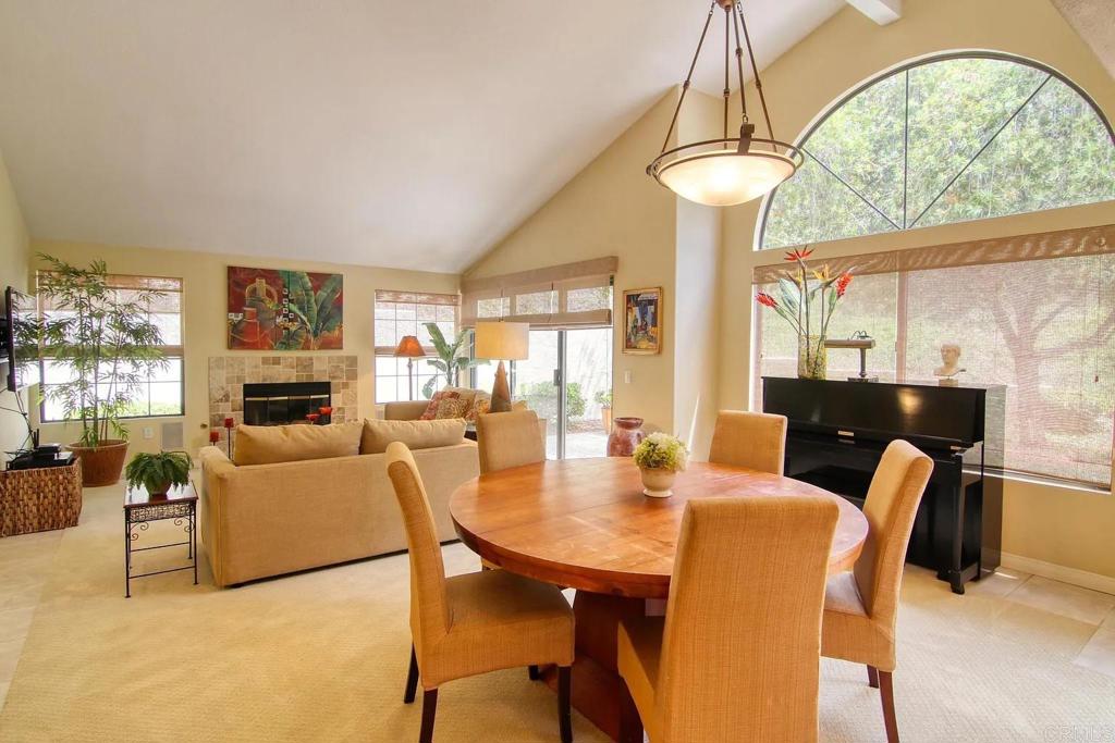7302 Paseo Verde Carlsbad, CA 92009 - Photo 8 of 24 a view of a dining room with furniture a chandelier and large windows