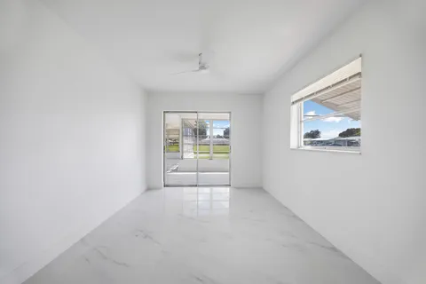 an empty room with windows and cabinet