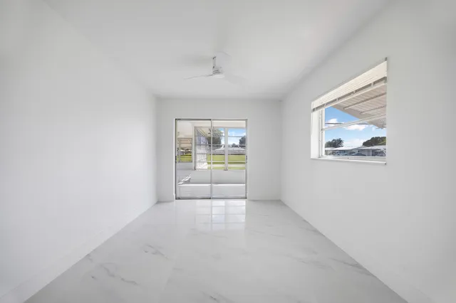 an empty room with windows and cabinet