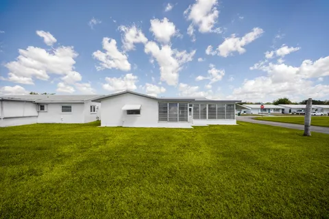 a front view of a house with a yard and potted plants