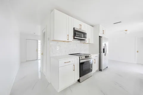 a kitchen with white cabinets and stainless steel appliances