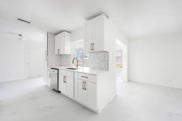 a kitchen with granite countertop white cabinets and white appliances