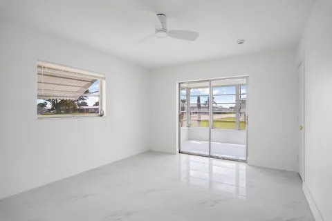 an empty room with a fireplace and a large window