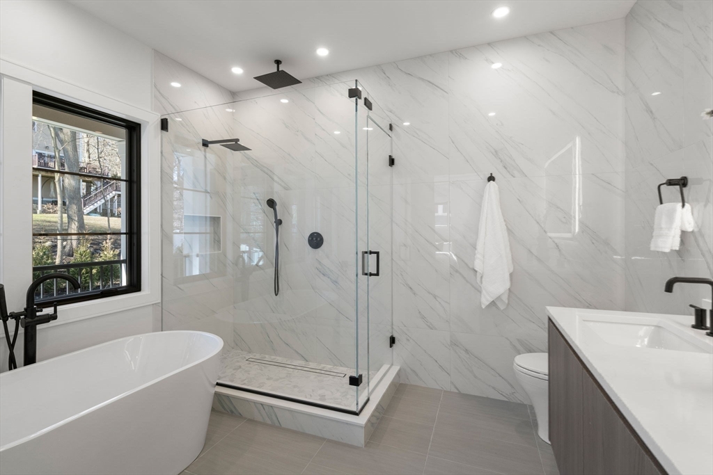 49 Ripley Street Newton, MA 02459 - Photo 14 of 32 a bathroom with a tub a sink shower and mirror