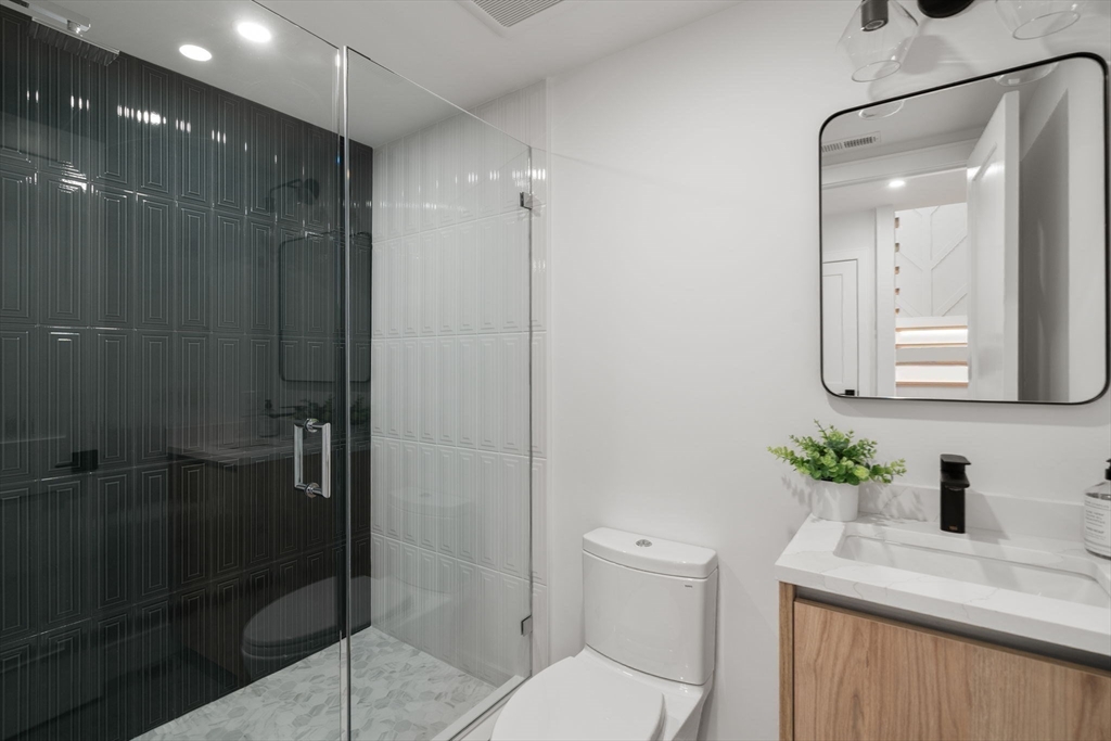 49 Ripley Street Newton, MA 02459 - Photo 25 of 32 a bathroom with a granite countertop sink a toilet and shower