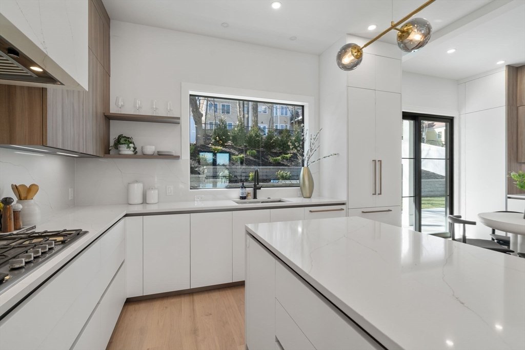 49 Ripley Street Newton, MA 02459 - Photo 7 of 32 a kitchen with kitchen island granite countertop a stove and a sink