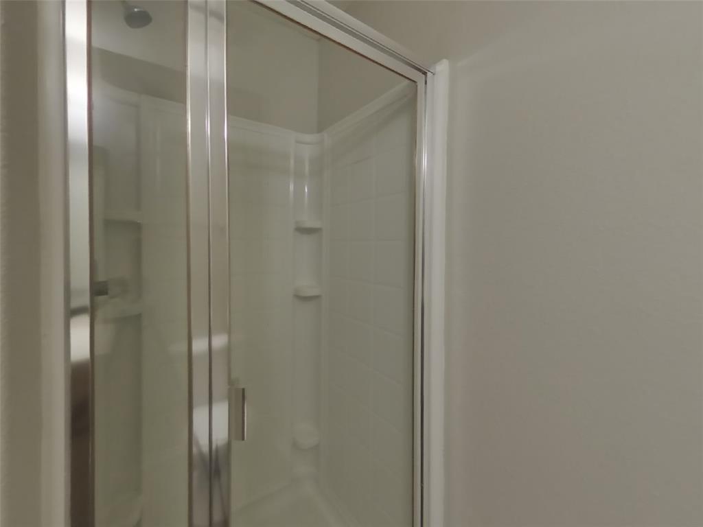 216 Rambling Way Forney, TX 75126 - Photo 14 of 22 a bathroom with a glass shower door