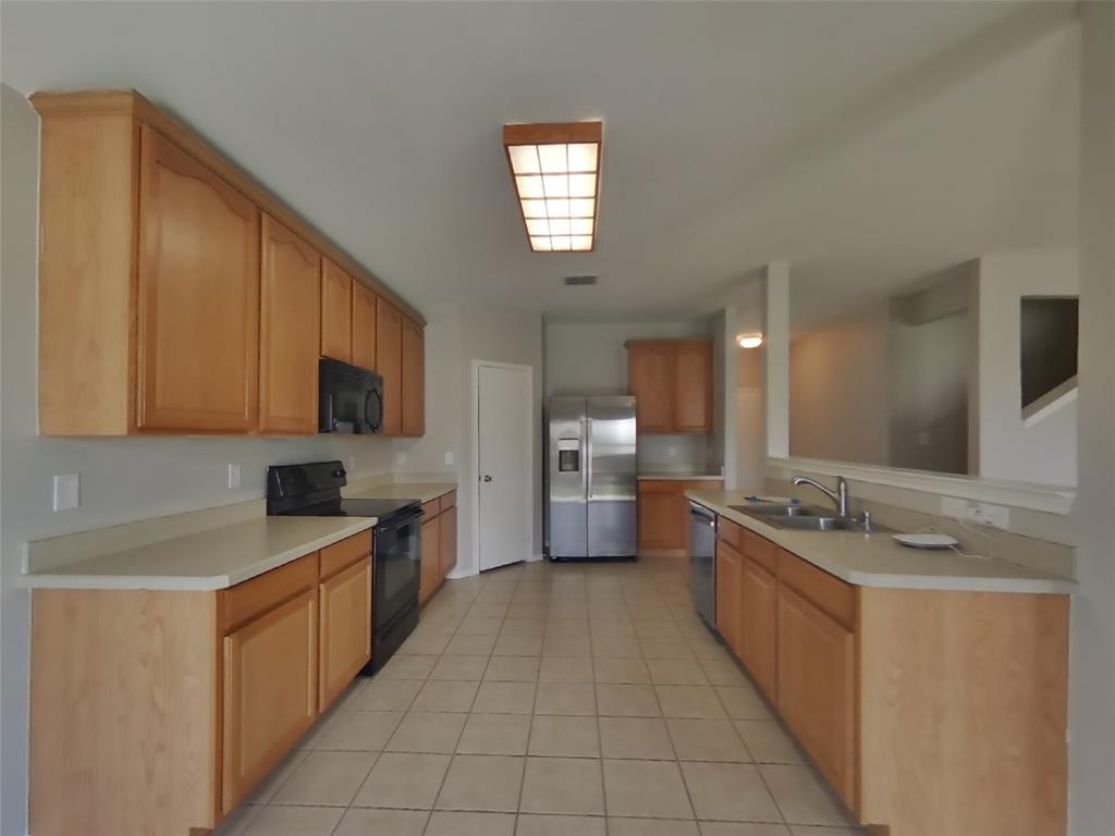 216 Rambling Way Forney, TX 75126 - Photo 5 of 22 a large kitchen with stainless steel appliances granite countertop a sink counter space cabinets and a sink
