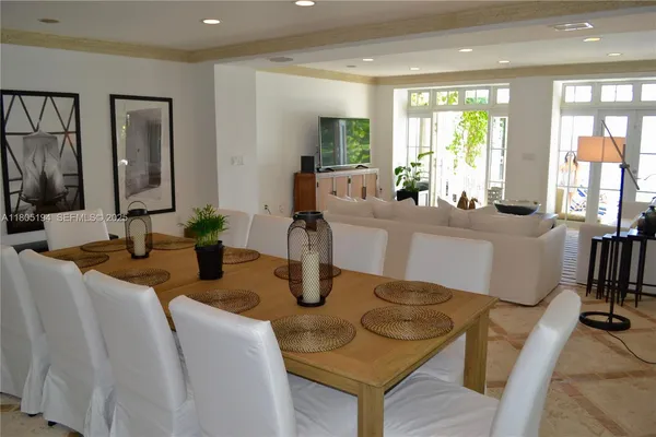 a dining room with furniture a large window and wooden floor