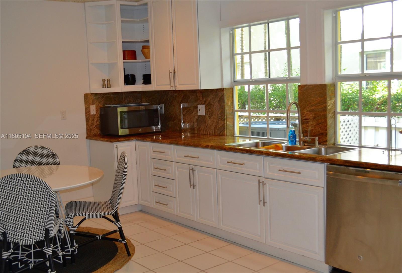 710 South Mashta Drive Key Biscayne, FL 33149 - Photo 4 of 13 a kitchen with stainless steel appliances a stove a sink and white cabinets