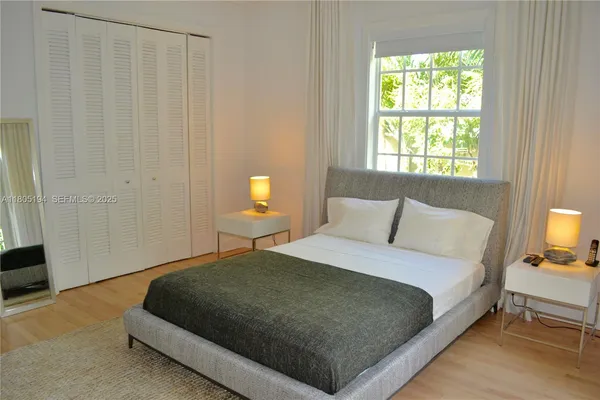 a bedroom with a bed lamp and a window