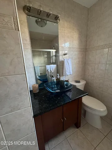 a bathroom with a granite countertop sink a toilet and a mirror