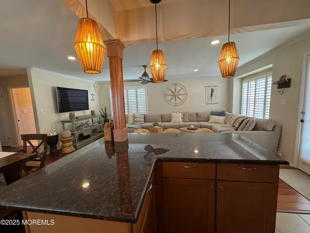 a kitchen with a sink a chandelier and living room view