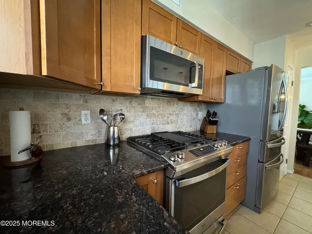 a kitchen with stainless steel appliances granite countertop a stove a microwave and a refrigerator
