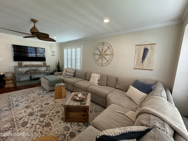 a living room with furniture a flat screen tv and kitchen view