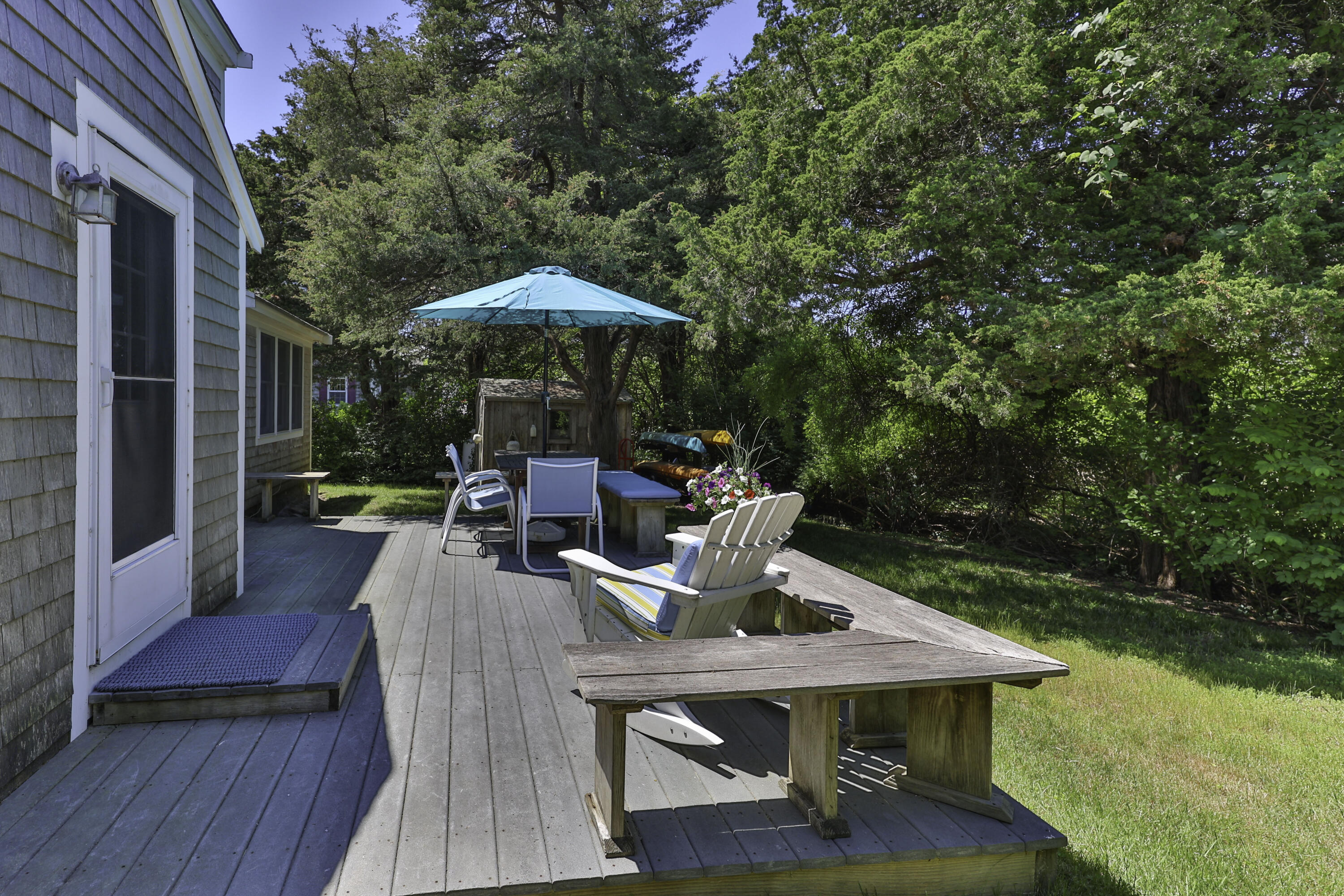 15 Doane Way Orleans, MA 02653 - Photo 28 of 54 a view of a patio with lawn chairs wooden floor and a yard