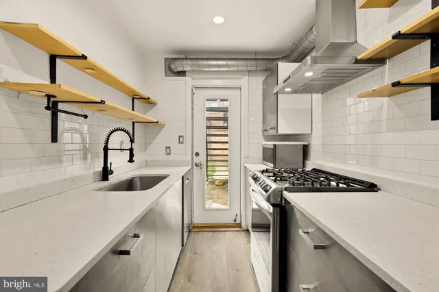a kitchen with a sink a stove cabinets and a refrigerator