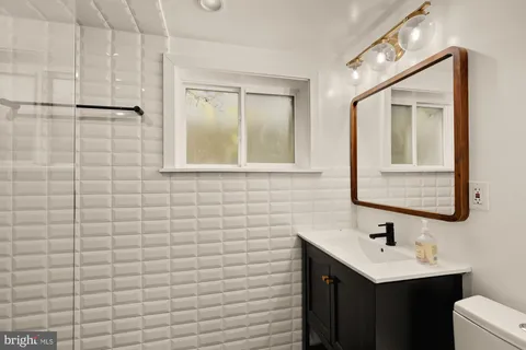 a bathroom with a sink a toilet and mirror