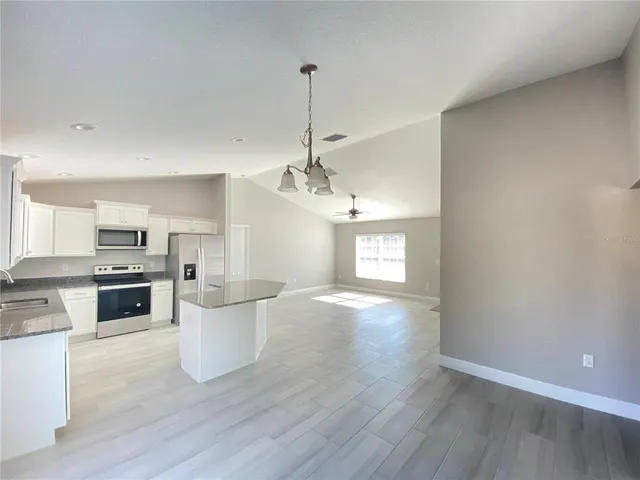 a view of a kitchen with a sink a stove and wooden floor