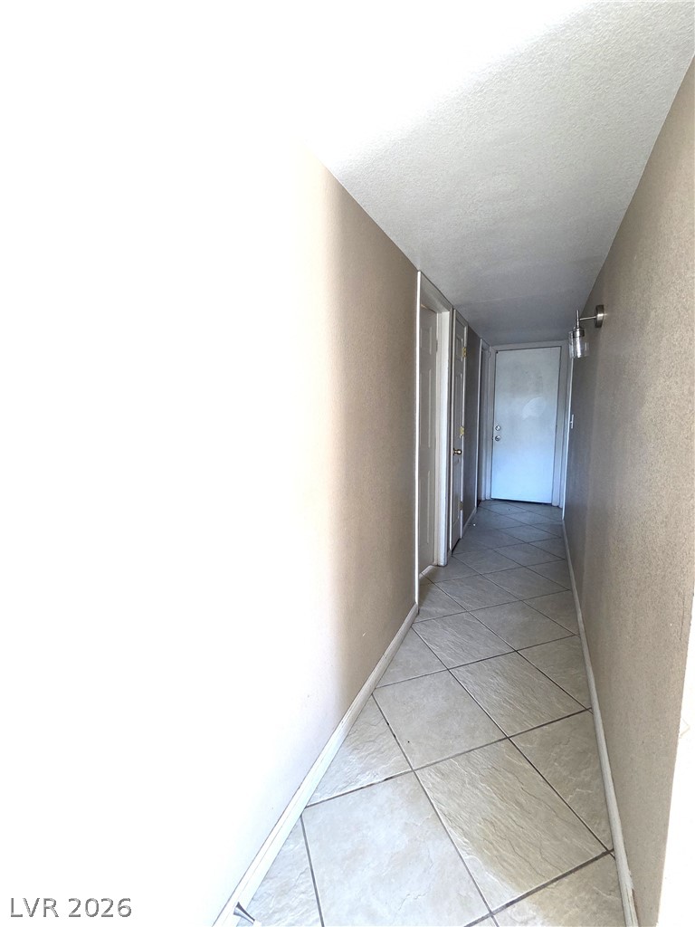 2882 Sandyfalls Way Las Vegas, NV 89142 - Photo 12 of 18 A long, tiled hallway provides access to multiple rooms within the residence.