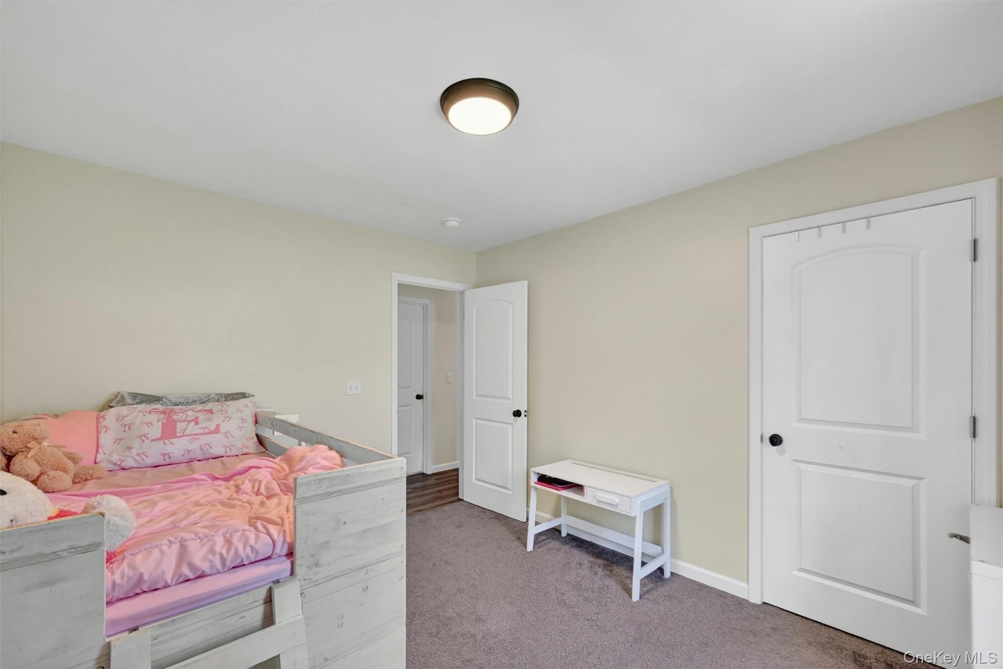 153 Ridge Drive Middletown, NY 10940 - Photo 30 of 47 a bedroom with a bed and a chandelier
