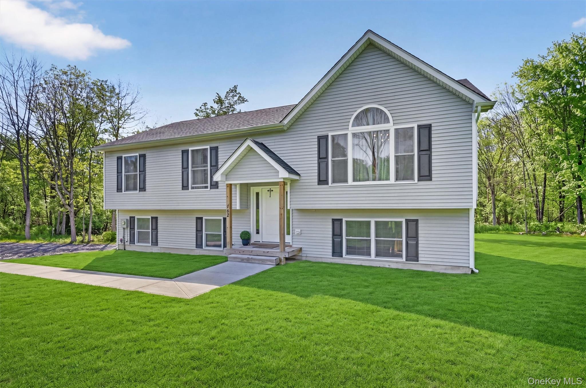 153 Ridge Drive Middletown, NY 10940 - Photo 3 of 47 a front view of a house with a yard and green space