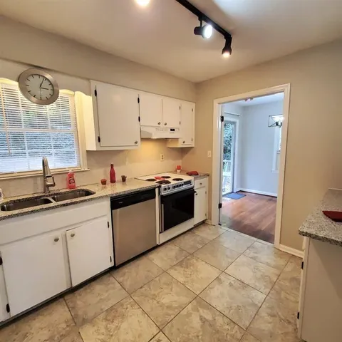 a kitchen with stainless steel appliances granite countertop a sink and cabinets