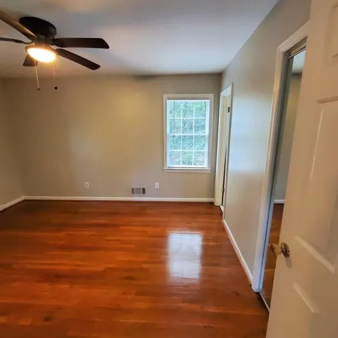 a view of an empty room with wooden floor