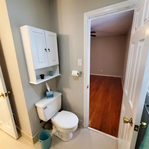 a white toilet sitting next to a sink and vanity