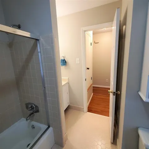 a bathroom with a tub shower vanity and a sink