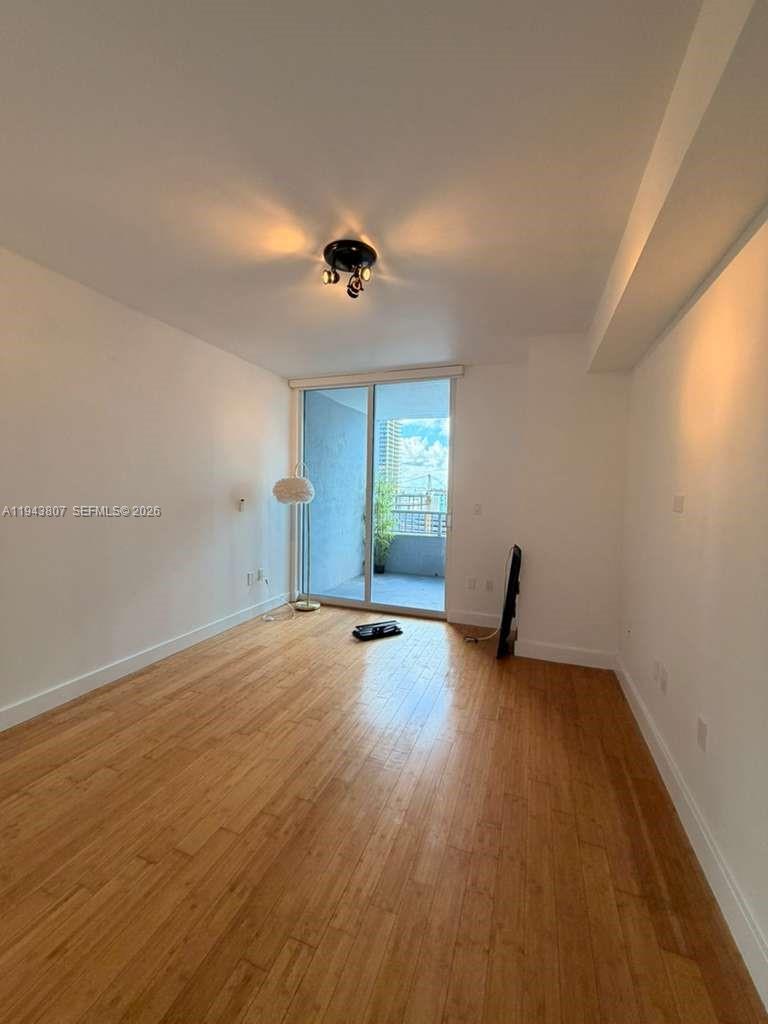 170 Southeast 14th Street, Unit 1807 Miami, FL 33131 - Photo 5 of 11 an empty room with wooden floor and windows