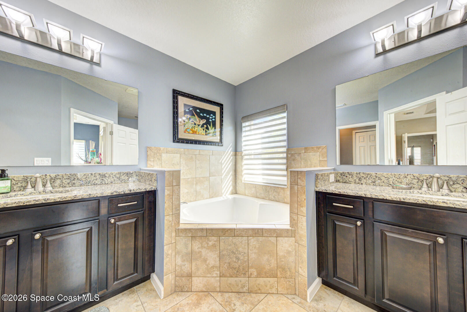 2975 Louetta Circle Melbourne, FL 32901 - Photo 21 of 44 a bathroom with a granite countertop sink a mirror and a bathtub