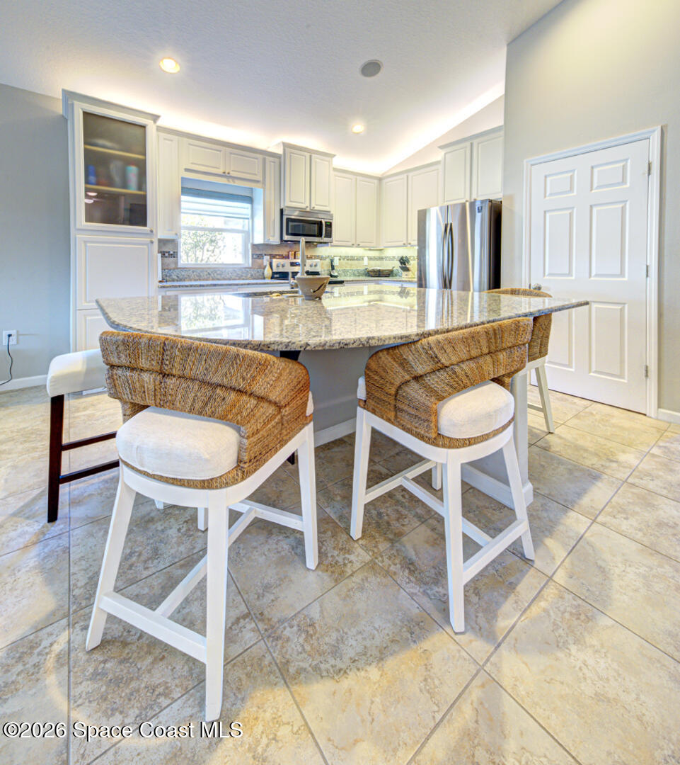 2975 Louetta Circle Melbourne, FL 32901 - Photo 8 of 44 a dining room with stainless steel appliances furniture a dining table and chairs