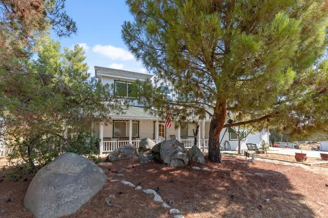 a view of a house with backyard and a tree