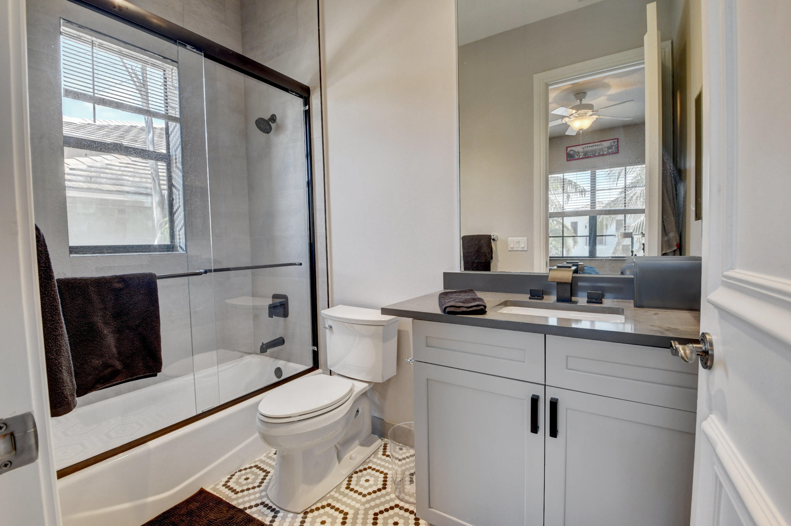 17798 Cadena Drive Boca Raton, FL 33496 - Photo 26 of 49 a bathroom with a granite countertop sink toilet a mirror and shower