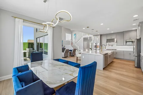 a living room with furniture kitchen view and a wooden floor