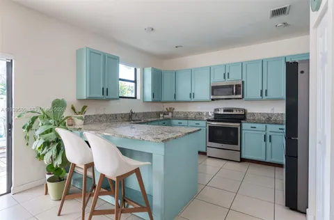 a kitchen with kitchen island granite countertop counter top space appliances and a center island