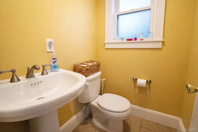 a bathroom with a sink and mirror with toilet