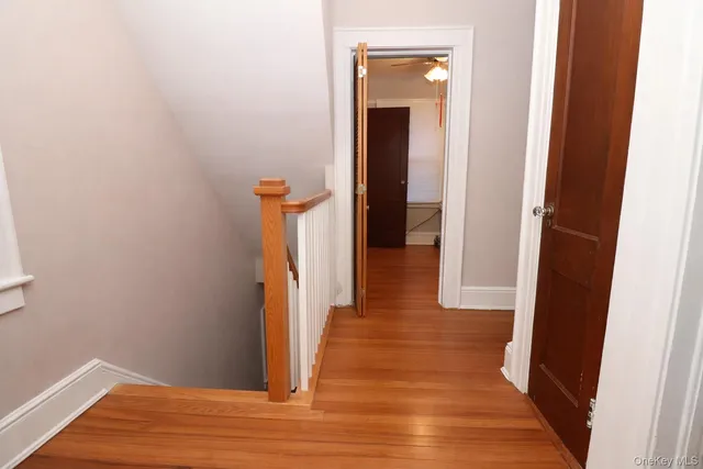 a view of a hallway with wooden floor and staircase