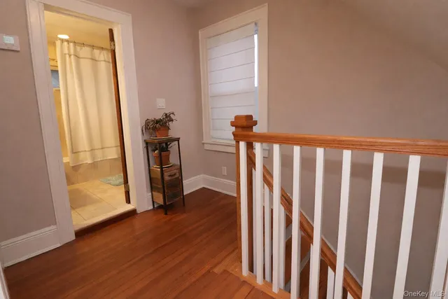 a view of a hallway with wooden floor and stairs