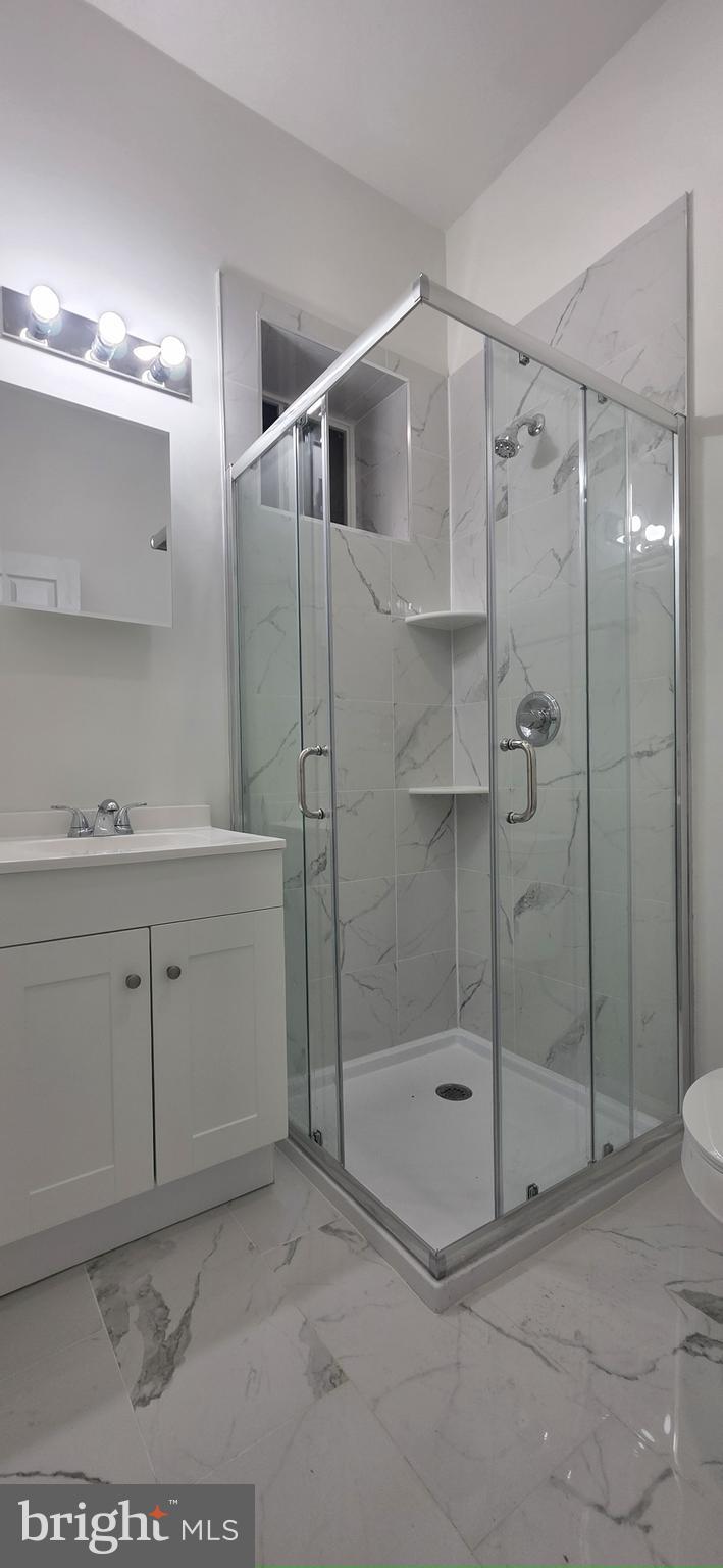 2233 North 16th Street Philadelphia, PA 19132 - Photo 21 of 21 a bathroom with a shower a sink and a mirror