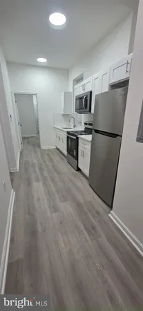 a kitchen with stainless steel appliances a refrigerator and a stove top oven