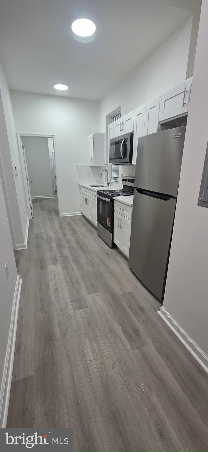 2233 North 16th Street Philadelphia, PA 19132 - Photo 6 of 21 a kitchen with stainless steel appliances a refrigerator and a stove top oven
