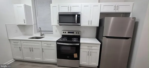 a kitchen with stainless steel appliances a refrigerator stove and microwave