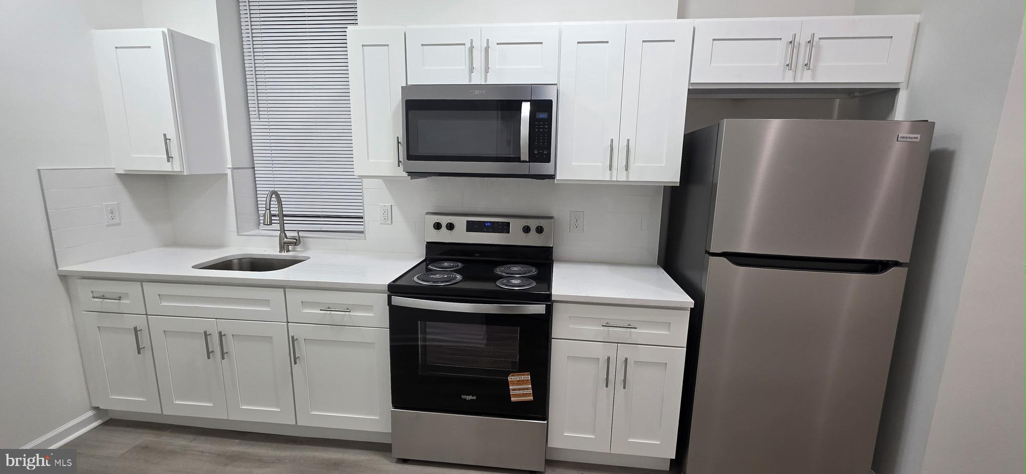 2233 North 16th Street Philadelphia, PA 19132 - Photo 7 of 21 a kitchen with stainless steel appliances a refrigerator stove and microwave