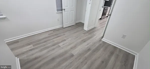 an empty room with wooden floor and entrance