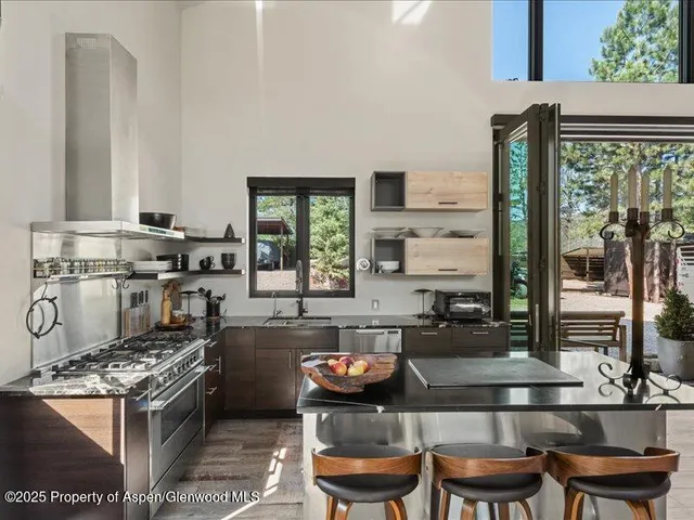 a kitchen with kitchen island granite countertop a stove and a white cabinets