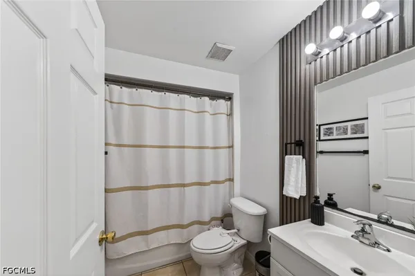 a bathroom with a sink a toilet and shower curtain