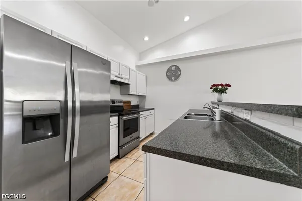 a kitchen with stainless steel appliances granite countertop a refrigerator a sink and dishwasher