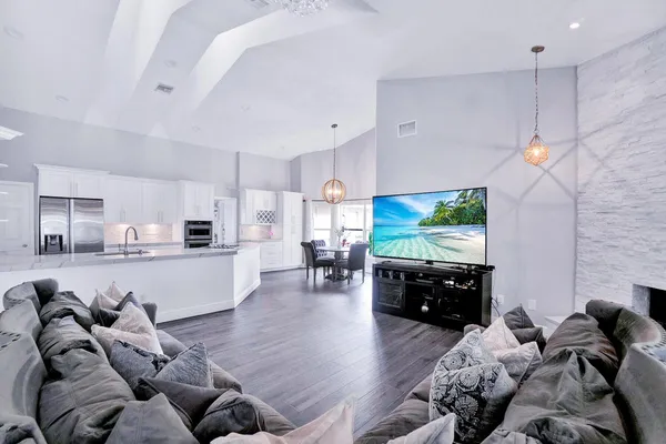 a living room with furniture kitchen view and a large window